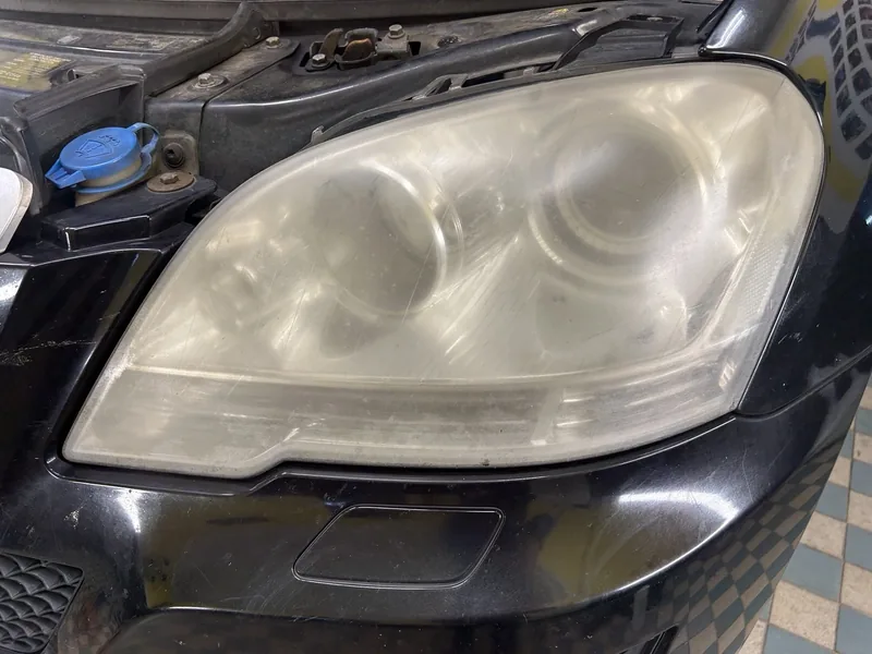 Zašlý světlomet Mercedesu ML před renovací.