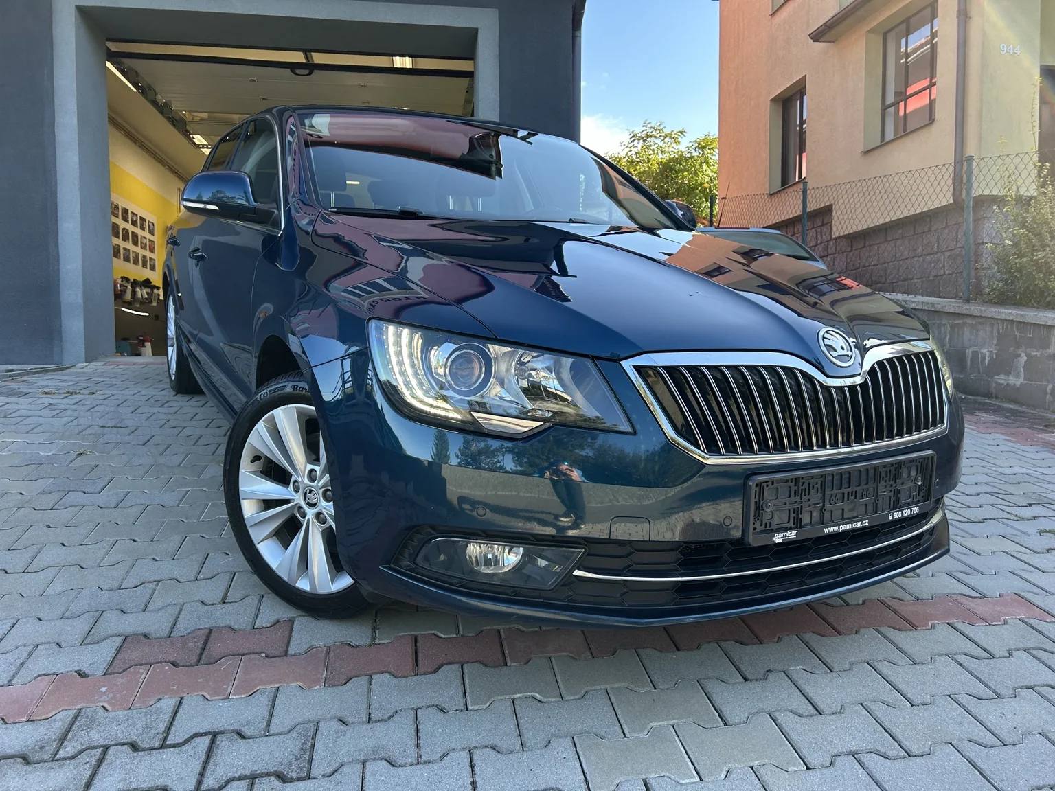 Modrá Škoda Superb II zepředu po lehkém přeleštění laku.