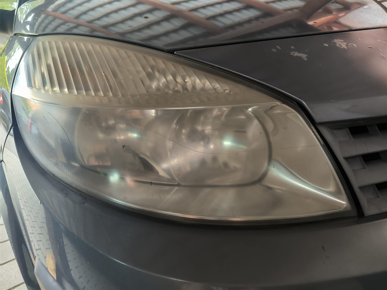 Renault Scénic se zažloutlým světlometem před renovací